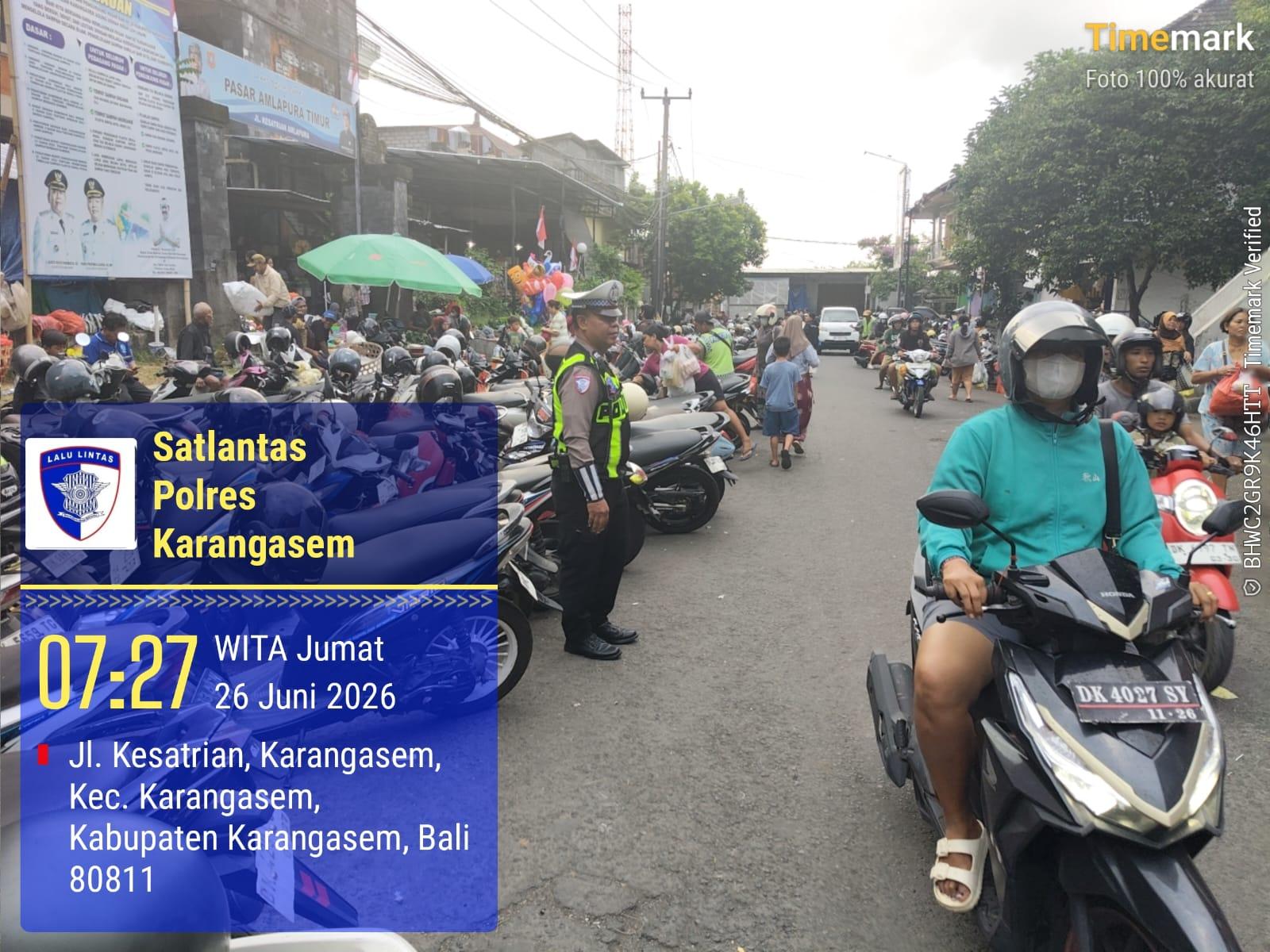 Penampahan Kuningan, Sat LAntas  Laksanakan Tugas Menyebrangkan Pejalan Kaki di Pasar Kesatriaan Amlapura