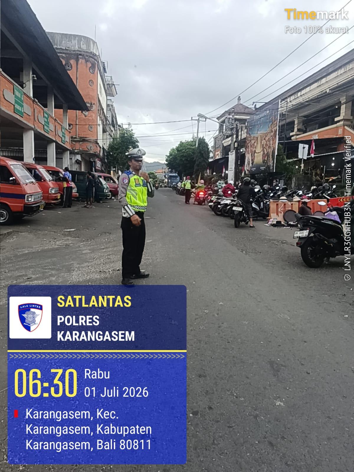 Laksanakan Pengaturan Lalulintas Pagi Hari, Anggota Sat Lantas Laksanakan Tugas Menyebrangkan Pejalan Kaki di Pasar Amlapura