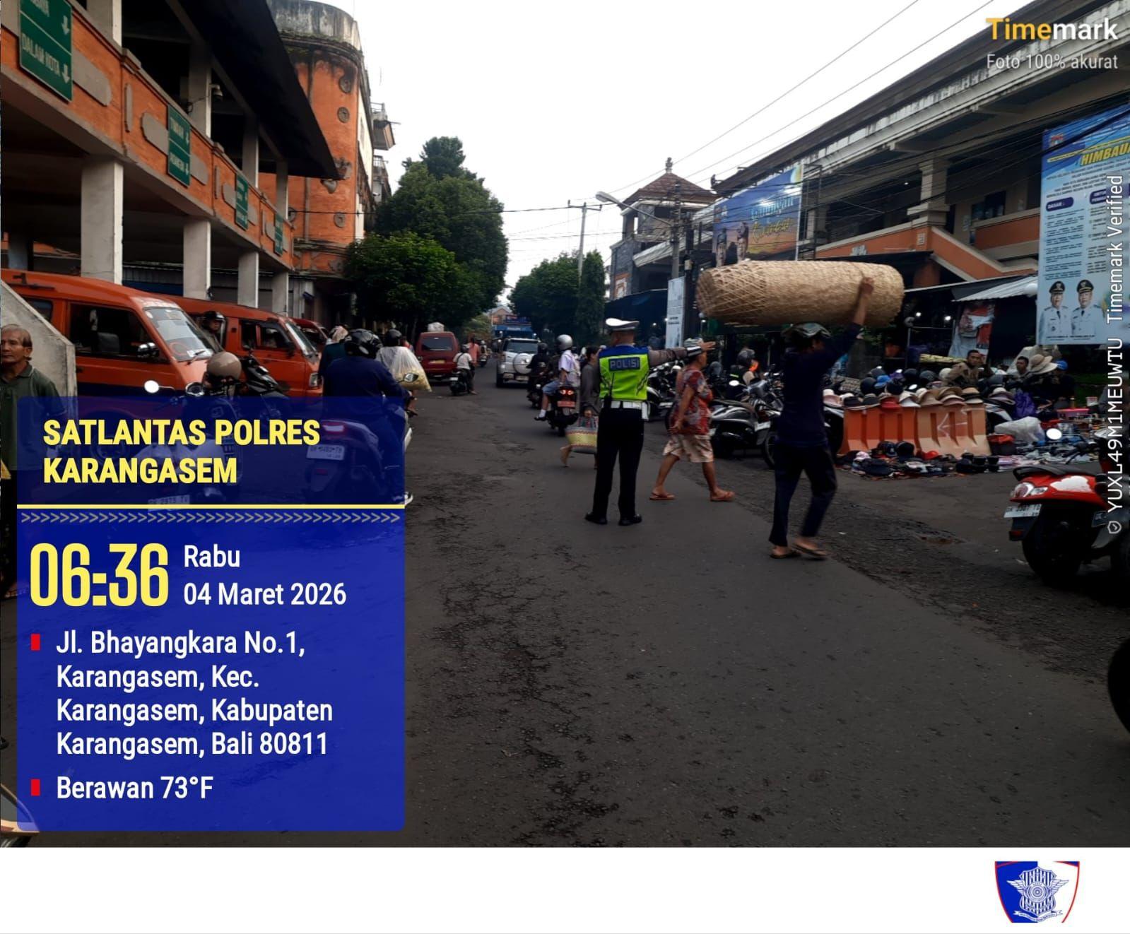 Utamakan Pejalan Kaki, Anggota Polres Karangasem Laksanakan Tugas Menyebrangkan Pejalan Kaki di Pasar Kesatriaan Amlapura