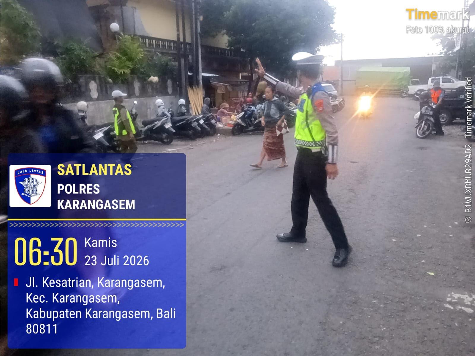 Utamakan Pejalan Kaki, Anggota Polres Karangasem Laksanakan Tugas Menyebrangkan Pejalan Kaki di Pasar Kesatriaan Amlapura
